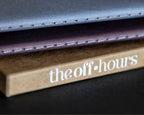 Close-up of The Off Hours 48-Hour Return hand-stitched books resting on the kraft slipcase